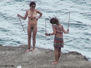 Подружки не подозревают, что их снимают, загорая у моря обнаженными