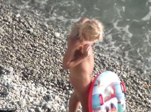 Молодая блондинка плавает в море голышом на надувном матрасе