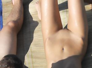 Парень с длинным членом загорает на пляже вместе с телочкой