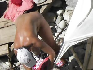 Загорелая крошка устанавливает палатку на пляже