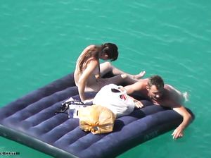 Девушка загорает без одежды на надувном матрасе