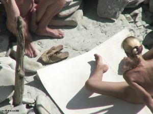 Блондинка играет с членом бойфренда на нудистском пляже