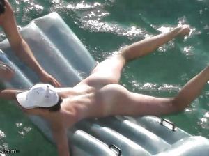 Муж учит жену плавать около нудистского пляжа