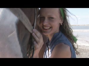 Две красивые цыпочки позируют в реке с лошадью