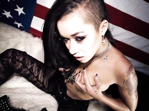 Татуированная мулатка в колготах позирует на фоне американского флага