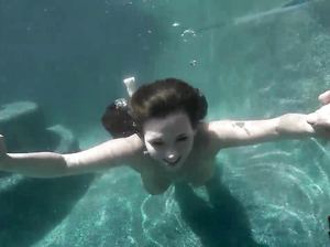 Брюнетка с красивыми сиськами тренируется в бассейне