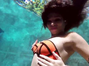 Темноволосая модель тренируется задерживать дыхание под водой