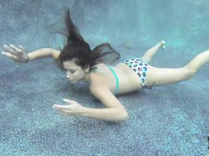 Стройная девушка пробует сосать резиновый член под водой