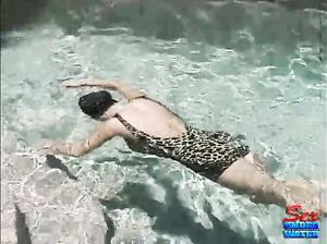 Куколка в винтажном леопардовом купальнике ныряет на дно бассейна
