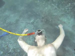 Девушка в маске поворачивается попой к парню под водой