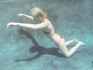 Крошка облизывает под водой резиновый самотык