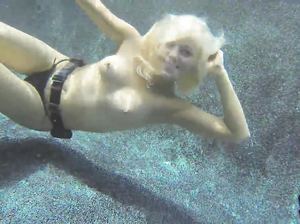 Крошка раздевается под водой и улыбается