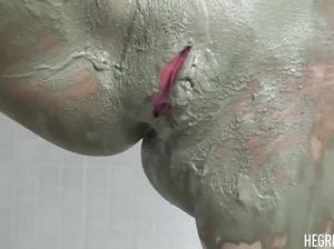 Стройная голая девушка измазала тело глиной