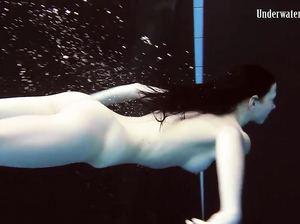 Худенькая брюнетка искусно выписывает пируэты под водой