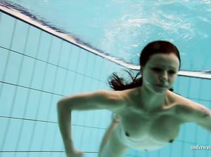 Обнаженная куколка искусно плавает под водой