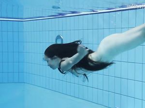 Обнаженная русалочка плавает под водой в бассейне