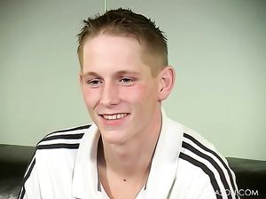 Серьезный парень гей присел на кожаный диван вздрочнуть