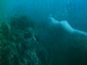 Голая красотка плавает под водой на большой глубине