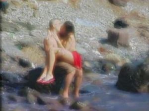 Зрелый мужчина отдыхает с брюнеткой на пляже