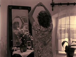 Игривая крошка разглядывает себя в зеркало