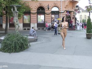 Голая брюнетка прогуливается по людной площади