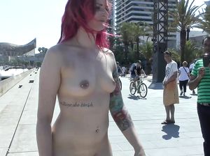 Рыжая с пирсингом в сиськах гуляет по городу голая