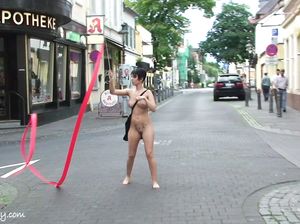 Голая гимнастка показывает трюки на улице