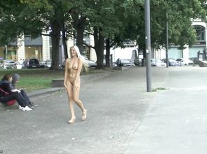 Красивая блондинка позирует голышом на площади